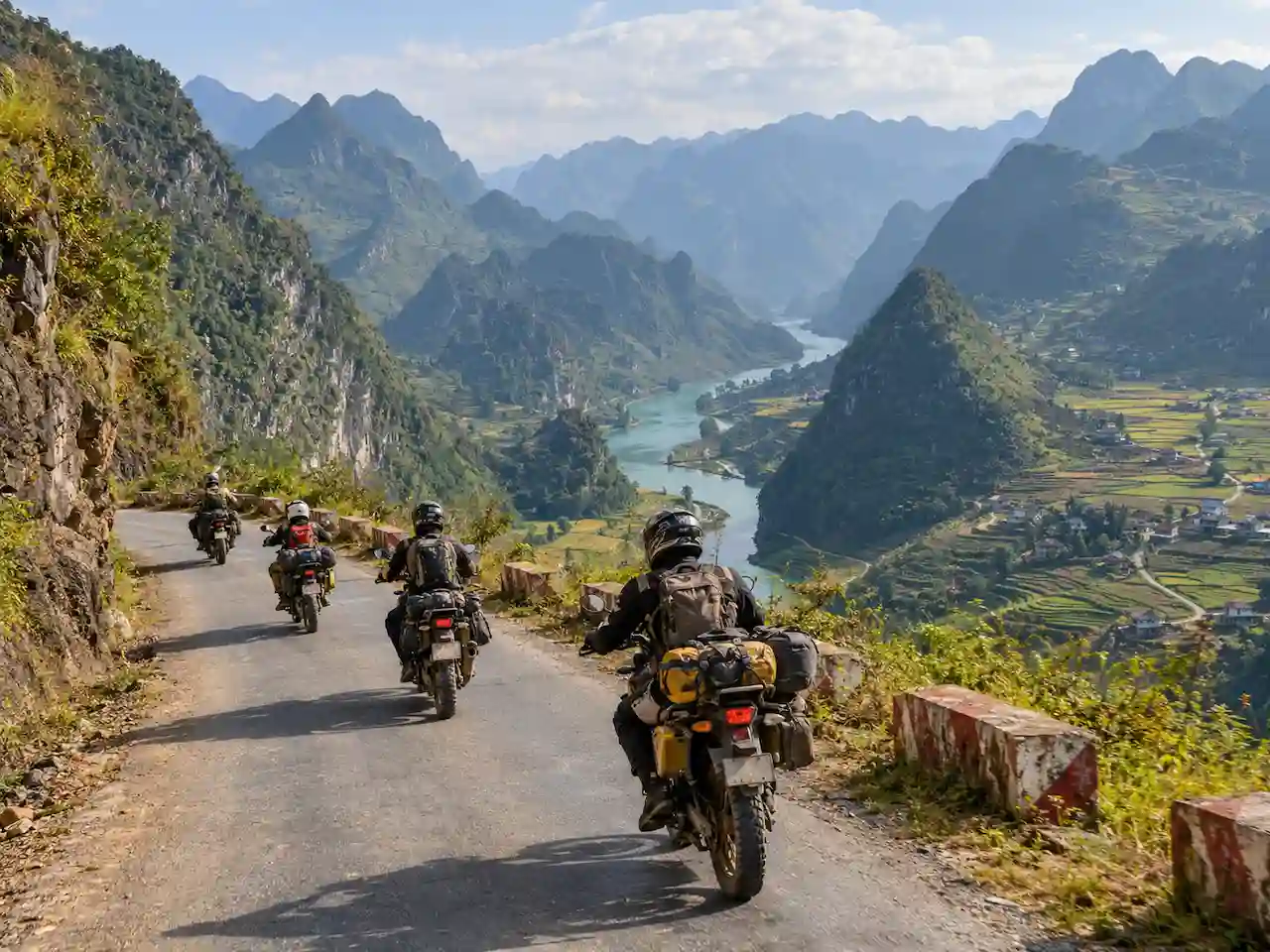 Motorcycle riders exploring winding mountain roads and scenic valleys in Ha Giang, North Vietnam.